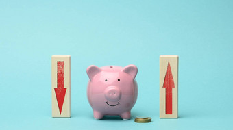 陶瓷粉红色的小猪银行木块红色的风扇箭头概念波动银行感兴趣下降不断上升的收入