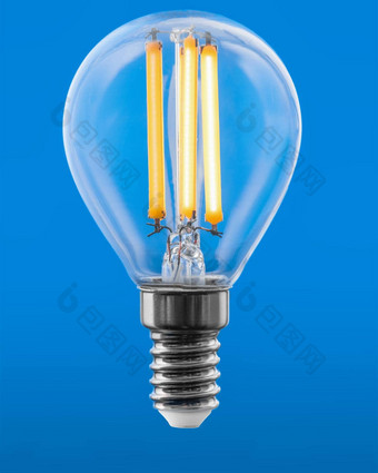 能源非常<strong>高效</strong>。领导灯丝光灯泡发光的孤立的蓝色的背景