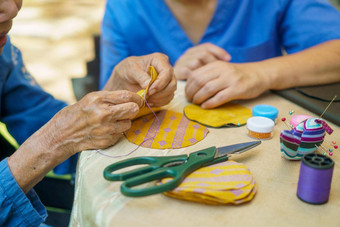 上了年纪的女人照顾者针工艺品职业治疗阿尔茨海默氏症痴呆
