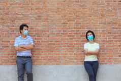 亚洲中间岁的人穿面具社会距离避免传播新冠病毒