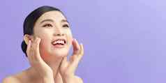 美丽的微笑亚洲女孩模型自然化妆触碰发光的水化皮肤