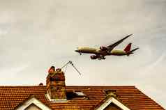 乘客飞机飞行屋顶住宅房屋低飞机苍蝇红色的屋顶瓷砖