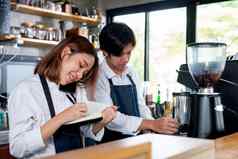 咖啡师女孩咖啡制造商回答移动电话记录订单细节笔记本同事工作机概念好团队合作支持小业务系统