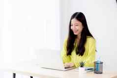 年轻的亚洲女商人工作移动PC电脑桌子上首页办公室自由打字笔记本表格生活方式女人研究在线业务教育概念