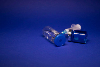 透明的疫苗瓶小玻璃瓶标签医疗注射器注射针孤立的<strong>蓝色</strong>的<strong>背景</strong>发展冠状病毒疫苗科维德治愈世界<strong>比赛</strong>研究