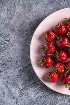 新鲜的成熟的草莓水果粉红色的板夏天维生素浆果灰色石头背景前视图