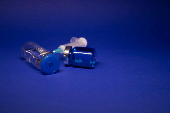 透明的疫苗瓶小玻璃瓶标签医疗注射器注射针孤立的蓝色的背景发展冠状病毒疫苗科维德治愈世界比赛研究