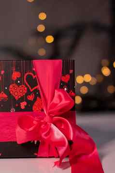 黑色的心礼物盒子粉红色的丝带弓黄金散景背景