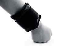 关闭人类手穿黑色的彩色的手腕重量手锻炼孤立的白色