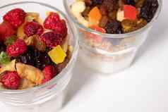 牛奶什锦早餐甜点酸奶蜜饯干水果树莓前玻璃孤立的白色背景格兰诺拉麦片早餐