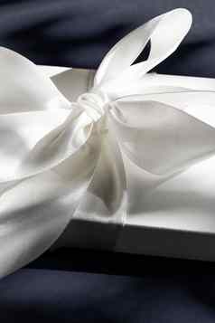 奢侈品假期白色礼物盒子丝绸丝带弓黑色的背景奢侈品婚礼生日现在