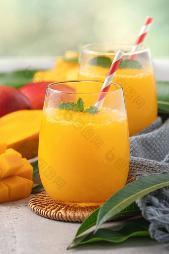 新鲜的美丽的美味的<strong>芒果汁</strong>奶昔玻璃杯灰色的表格背景