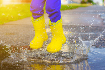 rubber-booted脚跳跃水坑文章橡胶靴子孩子们的夏天鞋子水坑雨坏天气孩子跳跃水坑快乐童年快乐男孩橡胶靴子跳跃水坑