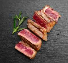 切片炸牛肉牛排纽约黑色的背景学位煮熟度罕见的