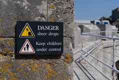 危险突然下降标志黄色的警告三角形象征男人。下降悬崖边缘孩子们控制标志