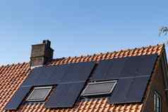 屋顶红色的屋顶瓷砖太阳能面板使可再生能源清晰的蓝色的天空