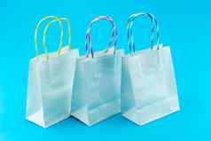 白色购物bagds蓝色的背景特写镜头拍摄色彩斑斓的购物袋
