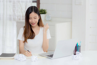 年轻的亚洲女人自信工作首页移动PC电脑思考的想法规划自由快乐女孩兴奋成功笔记本深思熟虑的<strong>写作业</strong>务概念