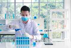 亚洲科学家们化学家实验滴蓝色的液体化学物质实验室