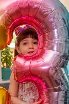 可爱的婴儿女孩持有数量气球