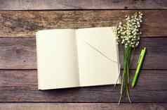 开放笔记本空白白色表花束盛开的百合谷木表格灰色的董事会