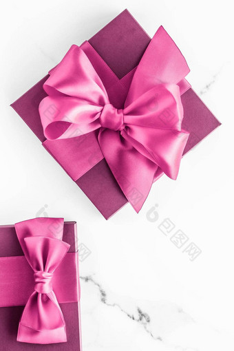 粉红色的礼物盒子丝绸弓大理石背景女孩婴儿淋浴现在魅力时尚礼物奢侈品美品牌假期平铺艺术设计