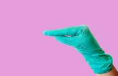女手蓝色的乳胶手套使手势类似鸭子的嘴隔离光粉红色的背景医疗健康概念复制空间