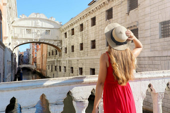 旅行威尼斯回来视图漂亮的女孩优雅的红色的衣服持有他桥叹了<strong>口气</strong>威尼斯意大利美丽的年轻的女人参观欧洲