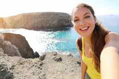 旅游女人采取自拍图片playa游船上景观快乐美丽的女孩肖像兰斯洛特景观playa游船上海滩金丝雀岛屿西班牙