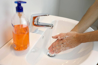科维德流感大流行冠状病毒男人。洗手摩擦肥皂水龙头水冠状病毒疾病防腐剂卫生医疗保健概念