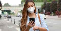 科维德年轻的女人穿断续器面具聪明的电话应用程序软件城市街援助联系跟踪诊断响应流感大流行冠状病毒