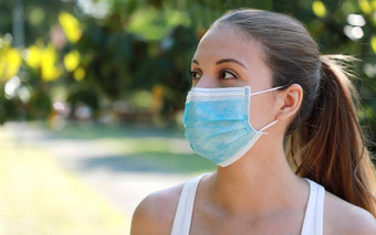 关闭健身女孩穿外科手术面具公园一边肖像年轻的运动女人保护面具脸冠状病毒疾病复制空间