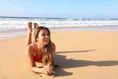 巴西微笑美丽的女孩说谎沙子享受太阳晒黑日光浴泳衣放松金丝雀岛热带海滩夏天假期一边复制空间区域