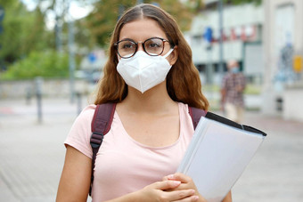 科维德美丽的学生女保护面具走城市街大学年轻的女人回来学校流感大流行冠状病毒