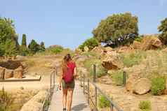 年轻的女人走谷寺庙agrigento西西里旅行者女孩访问希腊寺庙南部意大利