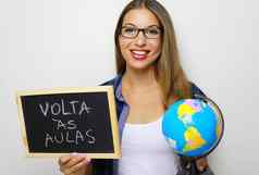 巴西年轻的女老师持有全球黑板上葡萄牙语写回来类回来学校