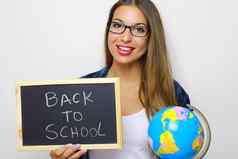 年轻的女老师持有全球黑板上写回来学校