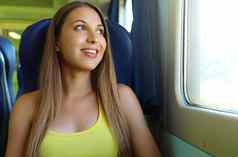 快乐美丽的年轻的女人火车公共汽车窗口微笑漂亮的火车乘客旅行坐着座位窗口