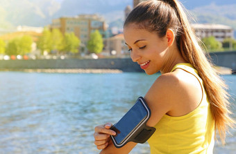 体育运动手镯智能手机运动女孩触碰聪明的电话户外健身锻炼海滩