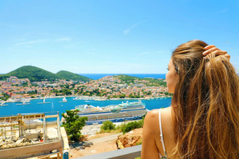 年轻的美丽的女人享受克罗地亚海岸杜布罗夫尼克城市夏天假期欧洲