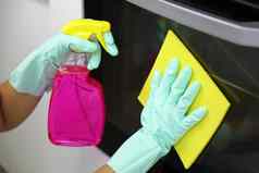 关闭女手保护手套清洁烤箱通过女孩抛光厨房人做家务清洁概念