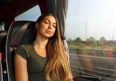 年轻的美丽的女人睡觉坐着公共汽车公共汽车乘客旅行坐着座位睡觉