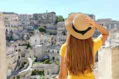 年轻的美丽的旅游女人参观历史小镇马泰拉意大利