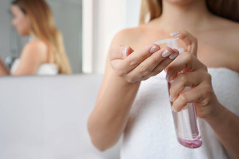 年轻的女人清洗石油环保删除化妆关闭女人手喷涂清洗石油焦点手