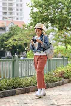 年轻的美丽的亚洲背包旅行者女人数字紧凑的相机微笑复制空间