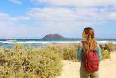 年轻的女背包客徒步旅行Fuerteventura岛西班牙