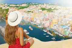美丽的年轻的女人他坐着墙惊人的全景视图procida岛那不勒斯意大利