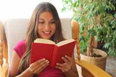 年轻的女人首页坐着舒适的椅子放松生活房间阅读书