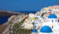 惊人的全景视图圣托里尼岛岛白色房子蓝色的穹顶著名的希腊度假胜地aio希腊欧洲旅行概念背景
