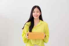 年轻的亚洲女人微笑持有纸板盒子首页快乐女携带包裹盒子给现在礼物包装交付在线购物商店服务概念